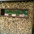 Gestapeltes Holz als Sichtschutz oder dekoratives Gartenelement