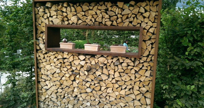 Gestapeltes Holz als Sichtschutz oder dekoratives Gartenelement