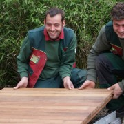 Holz wird oft im Garten verwendet, hier als Holzsteg mit Stahländern als Einfassung