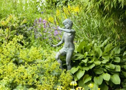 Gartenskulptur zwischen Stauden - Pan als Kupferfigur