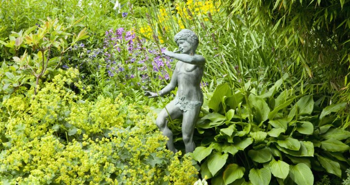 Gartenskulptur zwischen Stauden - Pan als Kupferfigur