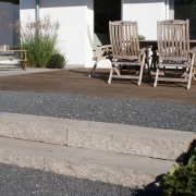 Tropenholz-Terrasse und Kiesfläche mit Sandsteinblockstufen