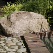 Findlinge unterbrechen eine gerade, gepflasterte Linie