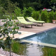 Gartenliegen auf Holzdeck am Pool