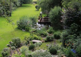 Langer Bachlauf mit Natursteinen und Granitbrücke