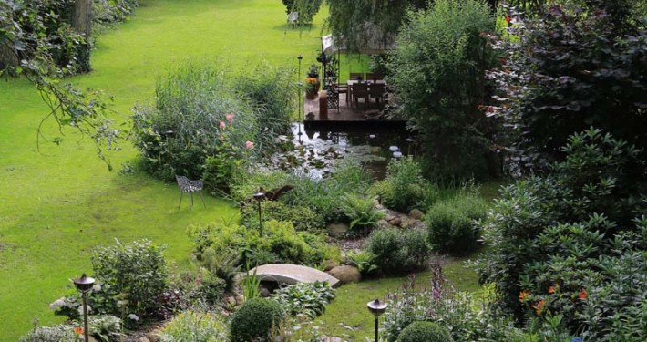 Langer Bachlauf mit Natursteinen und Granitbrücke