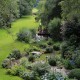 Langer Bachlauf mit Natursteinen und Granitbrücke