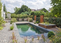 Wasser, Granit und Cortenstahl in Verbindung mit einem Fertigpoolbecken sieht sehr ästhetisch aus