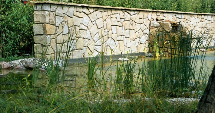 Natursteinmauern als Raumteiler direkt hinter dem Pool ist auch Sichtschutz