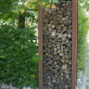 Holz-Sichtschutz mit Brennholz und Cortenstahl