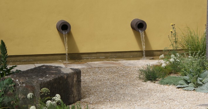 design Wasserspiel an gelber Mauer