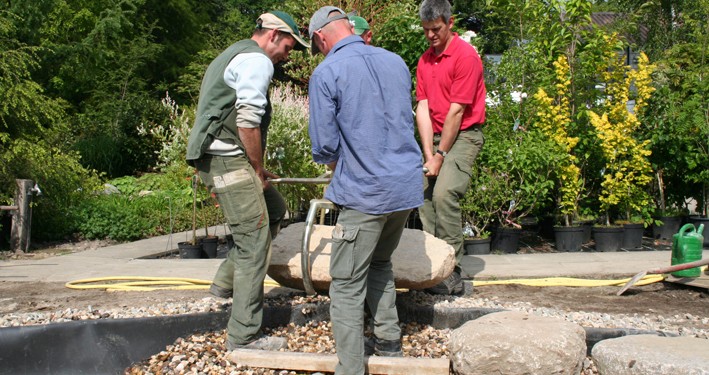 Versetzen von großen Findlingen als Trittsteine im Teich